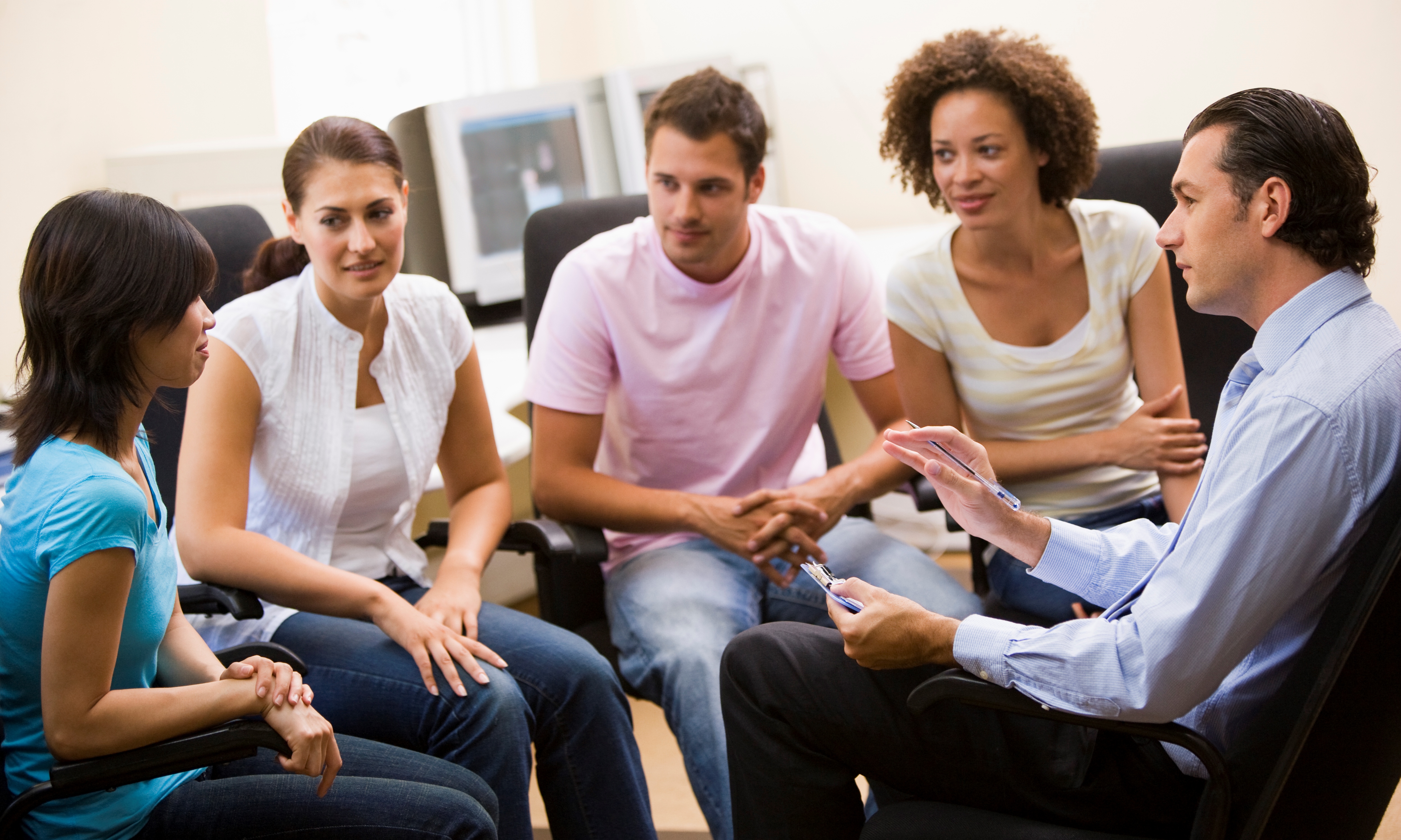 Man giving lecture to four people in computer room